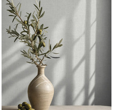 Behang met linnenlook in een lichte kamer met een keramische vaas en olijftakken.