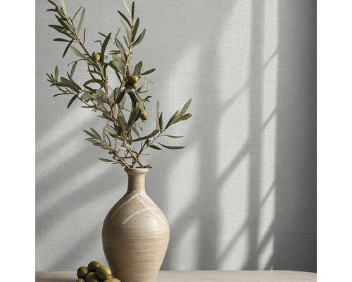Behang met linnenlook in een lichte kamer met een keramische vaas en olijftakken.