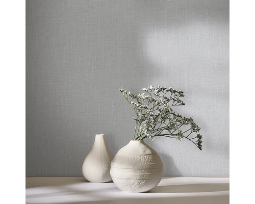 Vliesbehang met een fijne geweven structuur in linnenlook, afgebeeld met decoratieve vazen en bloemen.