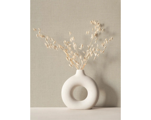 Ronde keramische vaas in ringvorm met gedroogde grassen voor een getextureerd behang met linnenlook.