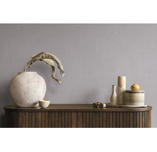 Vliesbehang met linnenstructuur in een minimalistische kamer met dressoir en decoratieve vazen.