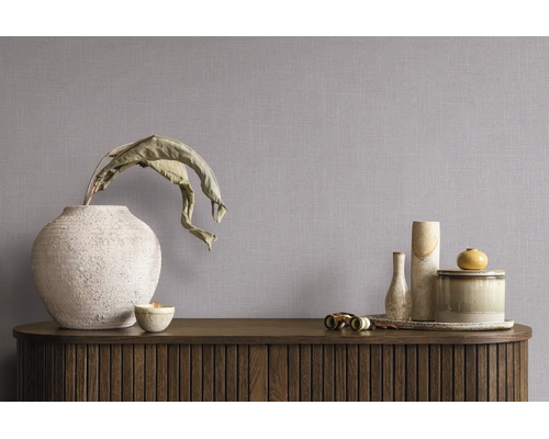 Vliesbehang met linnenstructuur in een minimalistische kamer met dressoir en decoratieve vazen.