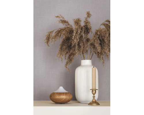Vliesbehang met linnenstructuur, gedecoreerd met een witte vaas met drooggrassen, een aroma-diffuser en een kandelaar.