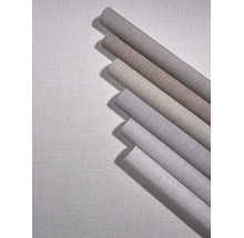 Meerdere rollen vliesbehang met linnenlook in verschillende neutrale tinten.