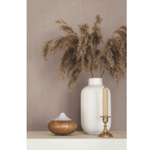Behang met linnenstructuur, gedecoreerd met een witte geribbelde vaas met drooggras, een aroma diffuser met houtlook en een kandelaar.