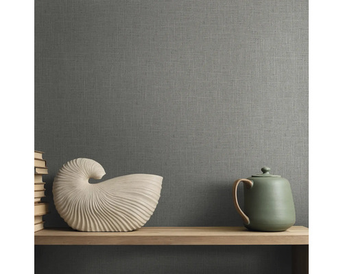 Behang met linnenstructuur in een kamer met een houten plank, een schelpvormig beeldje en een theepot.