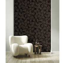 Vliesbehang met ginkgobladmotief in een lichte woonkamer met witte fauteuil en houten tafel.