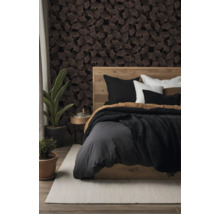Slaapkamer met donker behang met ginkgobladpatroon, een houten bed met grijs beddengoed, kamerplanten en een licht vloerkleed.