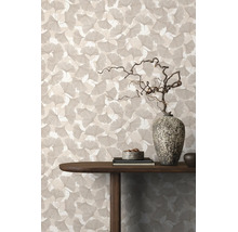 Behang met ginkgobladpatroon in een woonkamer met houten tafel en decoratieve stenen vaas.