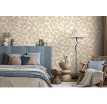 Vliesbehang met ginkgobladpatroon in een modern ingerichte slaapkamer met blauw bed en vloerlamp.