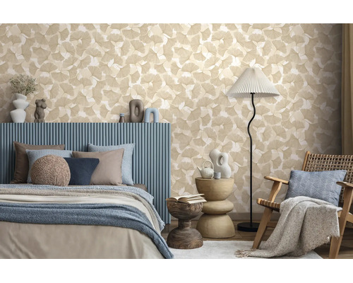 Vliesbehang met ginkgobladpatroon in een modern ingerichte slaapkamer met blauw bed en vloerlamp.