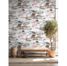 Vliesbehang met landschapsmotief in aquarelstijl, heuvels en bomen, in lichte kamer met houten bank en kamerplant.