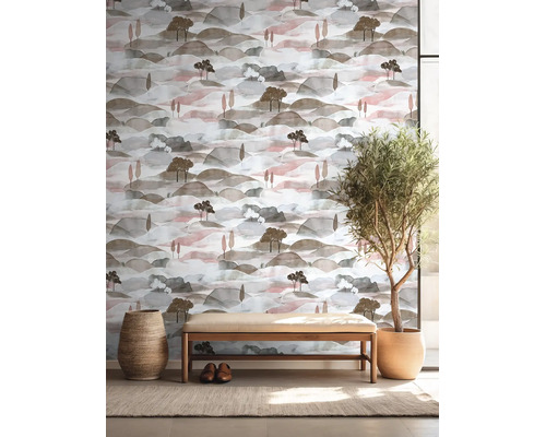 Vliesbehang met landschapsmotief in aquarelstijl, heuvels en bomen, in lichte kamer met houten bank en kamerplant.