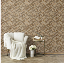 Moderne woonkamer met behang met geometrisch driedimensionaal patroon, witte fauteuil met gebreide plaid en gouden bijzettafel op houten vloer.