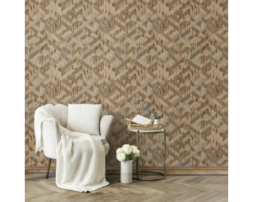 Moderne woonkamer met behang met geometrisch driedimensionaal patroon, witte fauteuil met gebreide plaid en gouden bijzettafel op houten vloer.