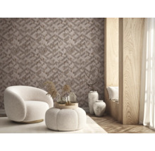 Moderne woonkamer met geometrisch behang met driedimensionale optiek en houtstructuur, een witte bouclé fauteuil en poef en vloervazen.