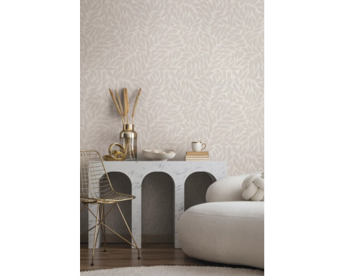 Lichte woonkamer met vliesbehang met bladmotief, marmeren consoletafel met bogen, gouden metalen stoel en witte bank.