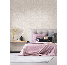 Lichte, moderne slaapkamer met behang met bladmotief, gestoffeerd bed en houten bijzettafel met decoratie.