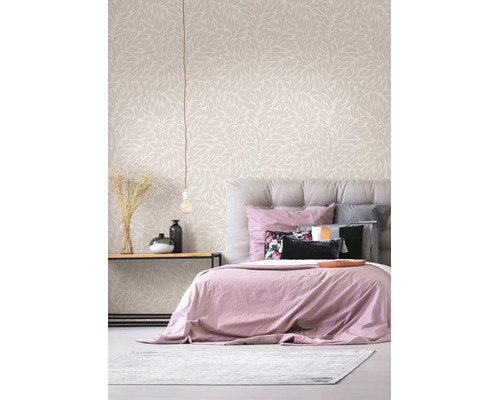 Lichte, moderne slaapkamer met behang met bladmotief, gestoffeerd bed en houten bijzettafel met decoratie.