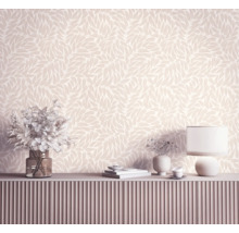 Vliesbehang met botanisch bladmotief in een lichte, moderne kamer boven een dressoir met verticale groeven.