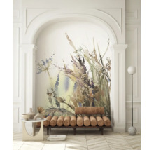Fotobehang met aquarel bloemenmotief in een nis met een bruine gestoffeerde bank en een vloerlamp.