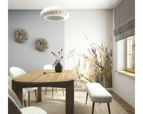 Lichte eetkamer met houten tafel, gestoffeerde stoelen en bank, een fotobehang met bloemenpatroon en een moderne hanglamp.