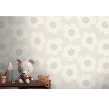 Behang met groot bloemenpatroon in een kinderkamer achter een plank met een knuffel en houten speelgoed.
