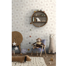 Kinderkamer met behang met groot bloemenpatroon, een ronde rotan wandplank en knuffels in een lichte, speelse Boho-stijl
