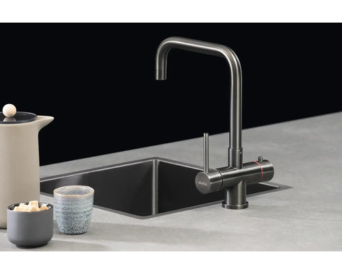 Moderne Selsiuz keukenmengkraan met hoge U-uitloop en eenhendelbediening bij een spoelbak in een minimalistisch ingerichte keuken.