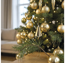 Kerstboom gedecoreerd met gouden ballen en kegels, verlicht met warmwitte LED-verlichting in een woonkamer.