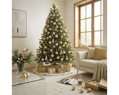 Feestelijk versierde kunstkerstboom met warmwitte lichtjes en gouden ballen in een lichte woonkamer met bank en cadeaus.