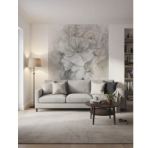 Moderne, lichte woonkamer met een grijze bank, donkere salontafel en een groot fotobehang met bloemen aan de wand achter de bank.