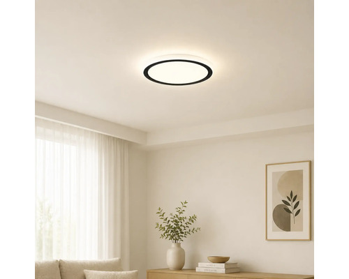 Moderne ronde LED-plafondlamp met zwarte rand in een lichte, minimalistische woonkamer met witte muren en lichte meubels.