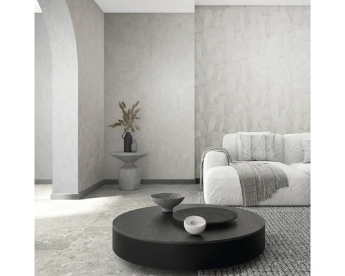 Moderne woonkamer met vliesbehang met patroon, gestructureerde wand, bank en ronde salontafel in een licht, minimalistisch ontwerp.