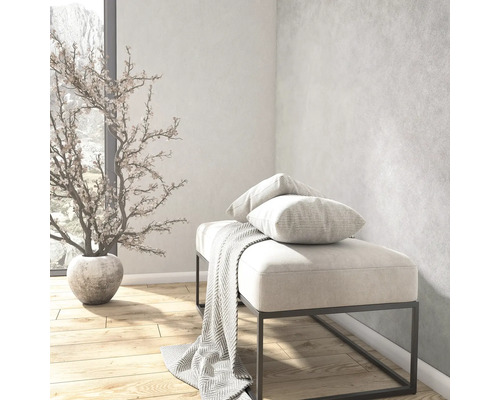 Lichte moderne kamer met gestoffeerde bank op metalen frame, kussens, deken, kunstplant in pot en houten vloer.