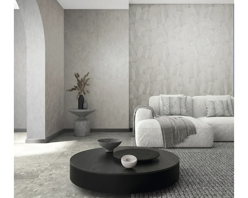 Moderne woonkamer met behang met textuur, bank, ronde salontafel en stenen vloer. Licht en georganiseerd.