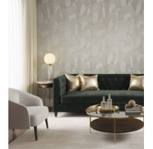 Behang met abstract boogpatroon in een moderne woonkamer met groene fluwelen bank, fauteuil en salontafel.