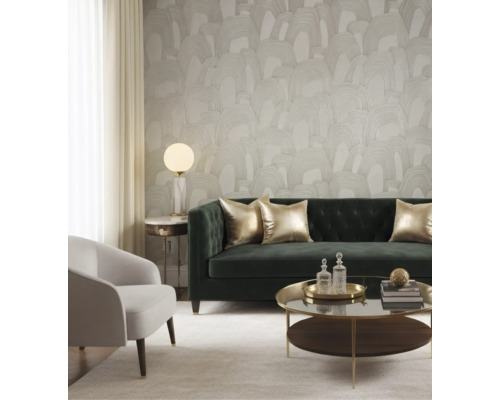 Behang met abstract boogpatroon in een moderne woonkamer met groene fluwelen bank, fauteuil en salontafel.