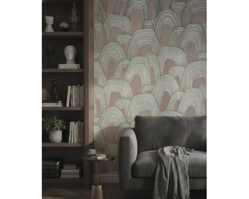 Vliesbehang met abstract boogpatroon achter een bank en een houten kast met boeken en decoratie.