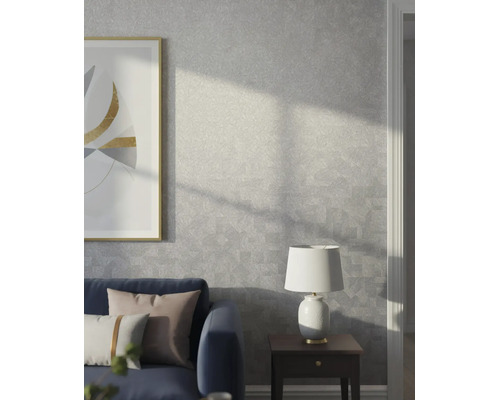 Moderne woonkamer met grijs structuurbehang met een subtiel geometrisch patroon, een blauwe bank, bijzetttafel en lamp.