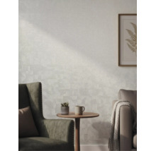 Gestructureerd behang in een lichte woonkamer met fauteuil, bijzettafel en wanddecoratie.