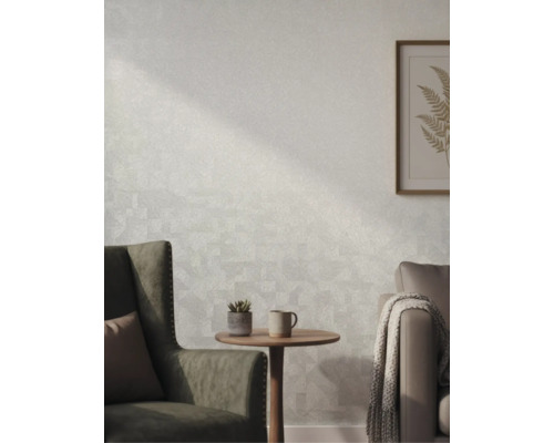 Gestructureerd behang in een lichte woonkamer met fauteuil, bijzettafel en wanddecoratie.