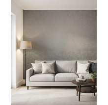 Lichte, moderne woonkamer met behang met textuur, stoffen bank met kussens, vloerlamp en ronde salontafel op een tapijt.