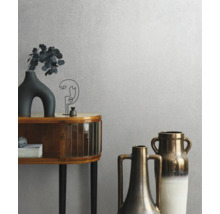 Behang met textuur in een lichte kamer met een houten dressoir en decoratieve vazen.