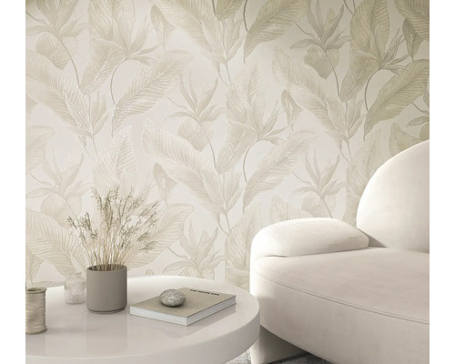 Vliesbehang met licht tropisch bladmotief in een lichte woonkamer met fauteuil en tafel