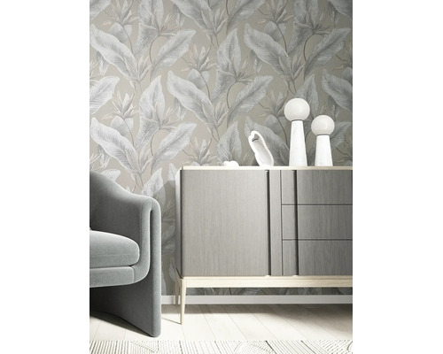 Vliesbehang met botanisch bladpatroon in een modern ingerichte kamer met grijs dressoir en fauteuil.