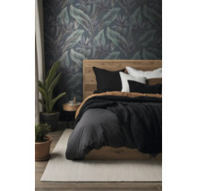 Moderne slaapkamer met vliesbehang met tropisch bladpatroon, houten bed, beddengoed en kamerplanten.
