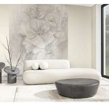 Lichte, moderne woonkamer met groot fotobehang met abstract bloemmotief, witte ronde bank en donkere ronde tafels.