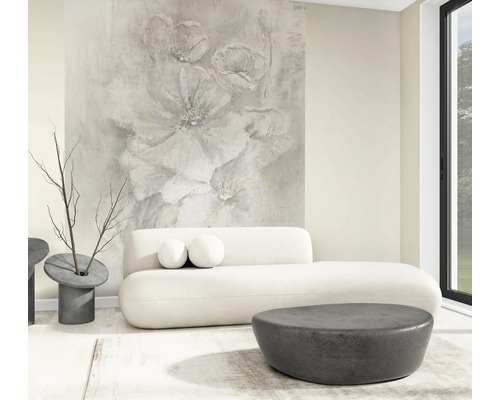 Lichte, moderne woonkamer met groot fotobehang met abstract bloemmotief, witte ronde bank en donkere ronde tafels.