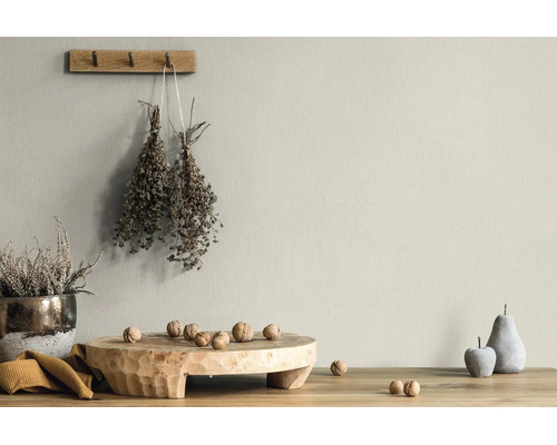 Matte muurverf in beige natuurtint in een lichte, rustieke kamer met houten decoratie en gedroogde planten.